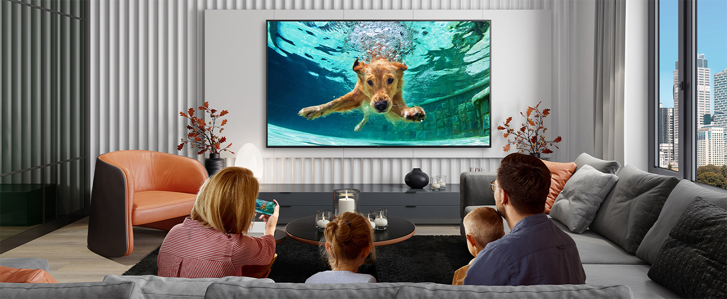 The image is showing a family streaming video content from their smartphone to the hotel TV using the casting service provided by LG Pro:Centric Cloud.